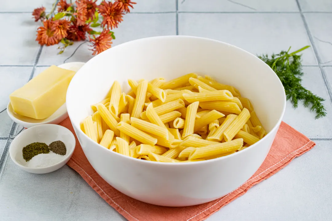 Ugotuj makaron w dużej ilości wrzącej, osolonej wody al dente, zgodnie z instrukcją na opakowaniu. Ugotowany makaron odcedź na durszlaku i przełóż do głębokiego naczynia.
