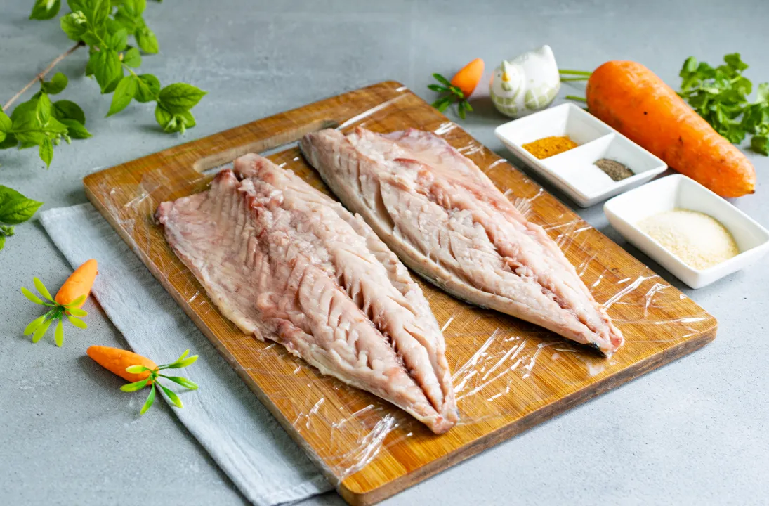 Cut off the mackerel's head, tail, and fins. Cut open the fish's belly, remove the insides and the black film inside. Rinse the fish thoroughly under cold water, pat the carcass dry with paper towels. Cut the fish into 2 fillets, remove the spine and bones. Place the mackerel on a cutting board lined with plastic wrap.
