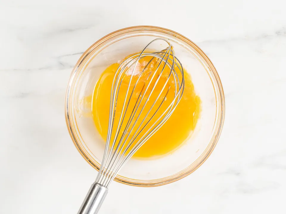 Carefully separate the egg whites from the yolks. Take a deep bowl. Crack an egg in half with a knife, allowing the white to drain out. Transfer the yolk back and forth between the two shell halves until all the white has dripped away. Then, place the yolks into the bowl designated for mixing the dough.