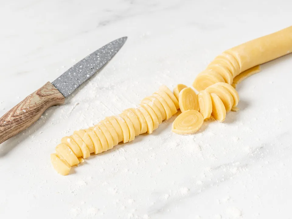 Lightly flour your work surface. Place the first portion of dough onto it and roll it out into a very thin sheet, about 0.5-1 mm thick.