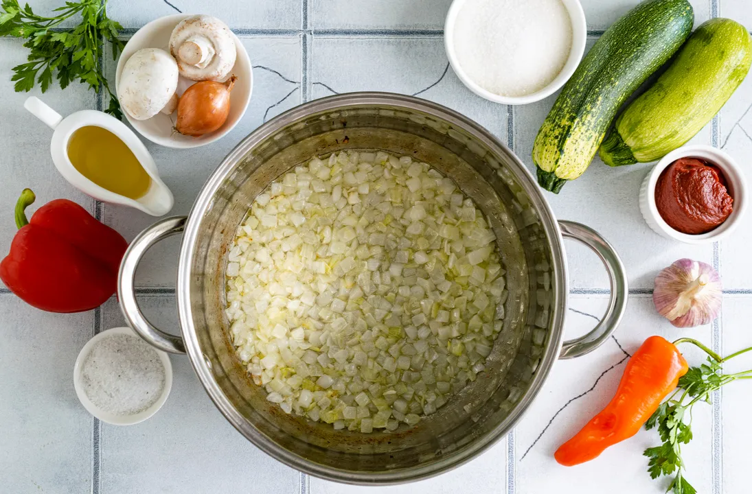 Peel the onion and chop it into small cubes. Place the vegetables in a large pot with heated sunflower oil. Sauté the onion over medium heat, stirring occasionally, until softened.