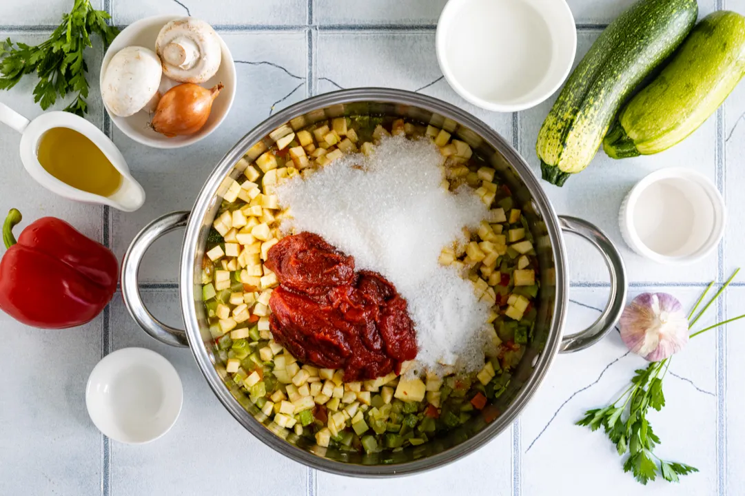 Add salt and sugar, then stir in the tomato paste. Mix the ingredients thoroughly. Simmer the zucchini caviar, covered, over low heat for 20 minutes until the vegetables are tender. Stir the caviar occasionally to ensure even cooking of all vegetables.