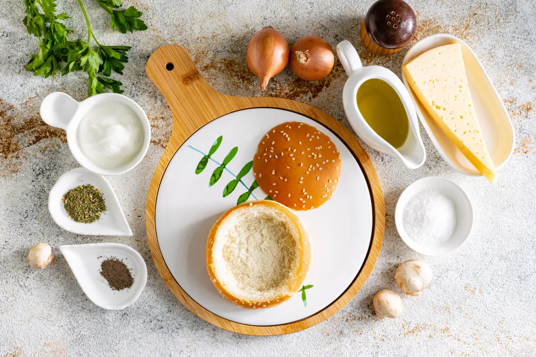 Közben készítse elő a zsemléket. Óvatosan vágja le a zsemlék tetejét, teáskanállal távolítsa el a belsejüket, így kosarakat formázva a kenyérből, aljával és peremével.