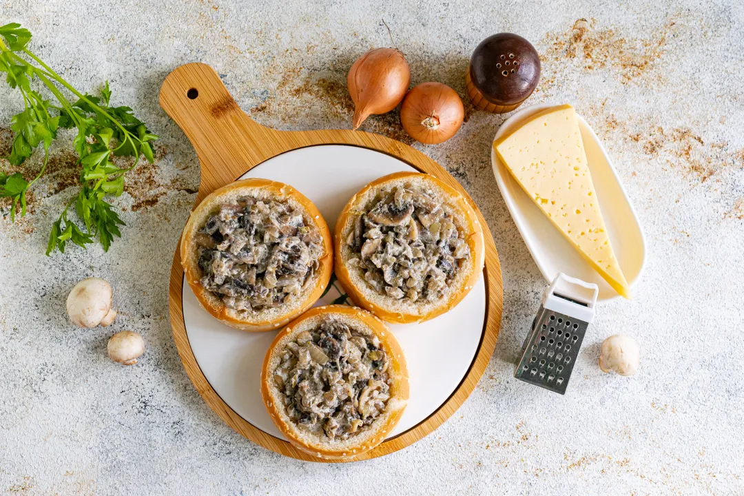 Töltse meg a gombás töltelékkel az előkészített zsemléket.