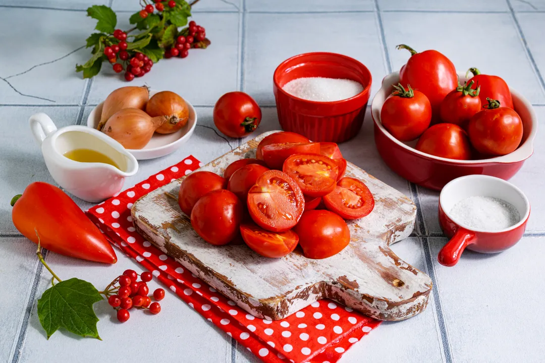 Mossa meg a paradicsomokat, vágja félbe, és távolítsa el a szárukat.