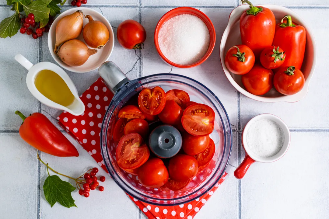 Tegye a zöldségeket a turmixgép táljába. Pürésítse a paradicsomot. Erre a célra húsdaráló is használható, finom rácsozattal.