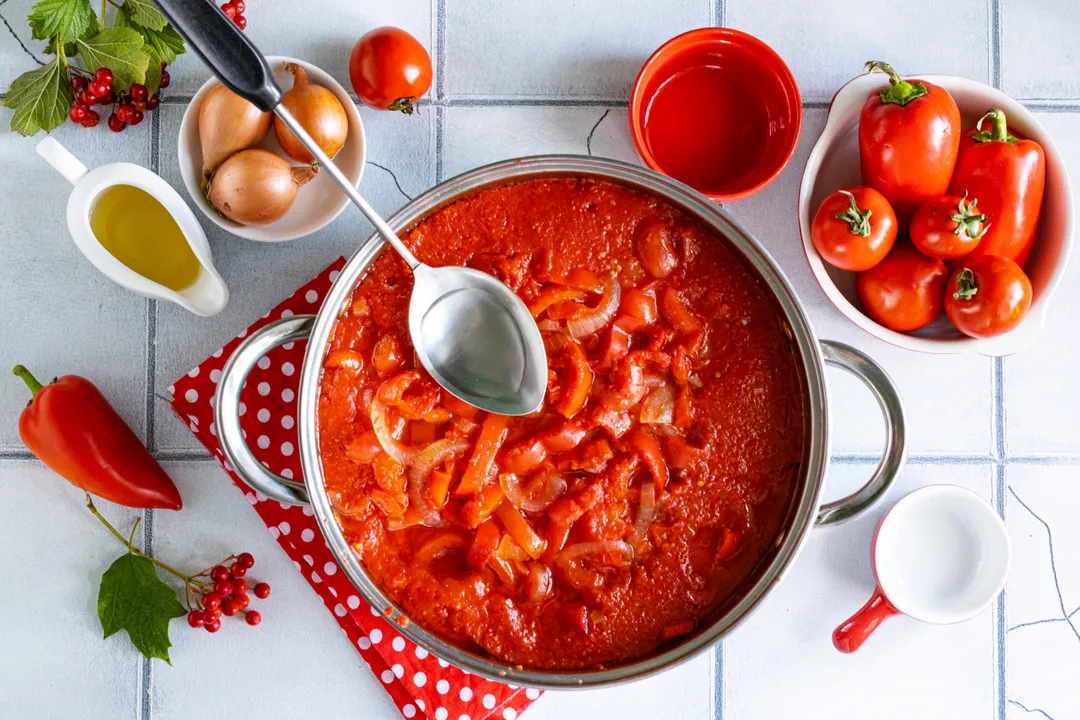 Párolja a zöldségeket paradicsomszószban, fedő alatt, lassú tűzön 30 percig. Főzés közben a zöldségek levet eresztenek, és kissé összeesnek. Ezután öntsön a lecsóba 9%-os ecetet, hogy a befőtt jól eltartható legyen egész télen. Folytassa a lecsó főzését további 2-3 percig.