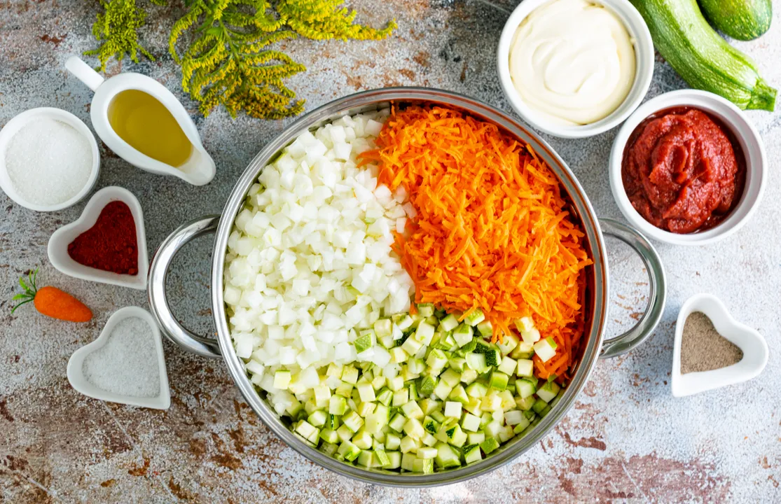 У глибокій каструлі з'єднайте підготовлені овочі: кабачки, ріпчасту цибулю та моркву.