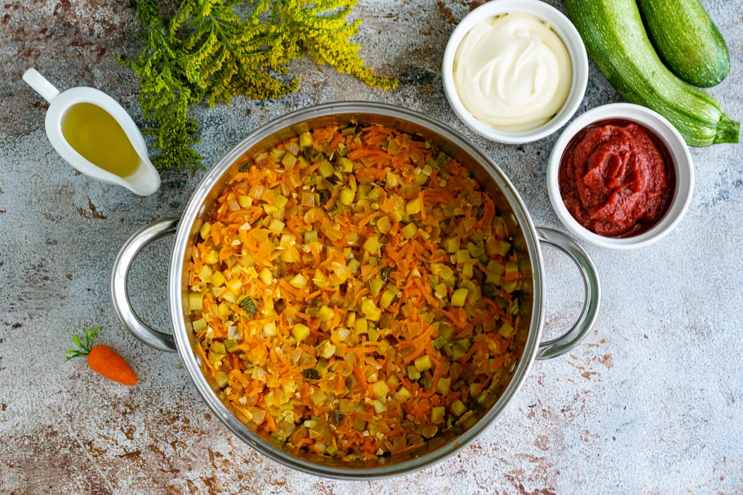 Накрийте каструлю кришкою, тушкуйте кабачкову ікру на повільному вогні протягом 1 години. За цей час овочі пустять сік, зменшаться в обсязі та стануть м'якими.