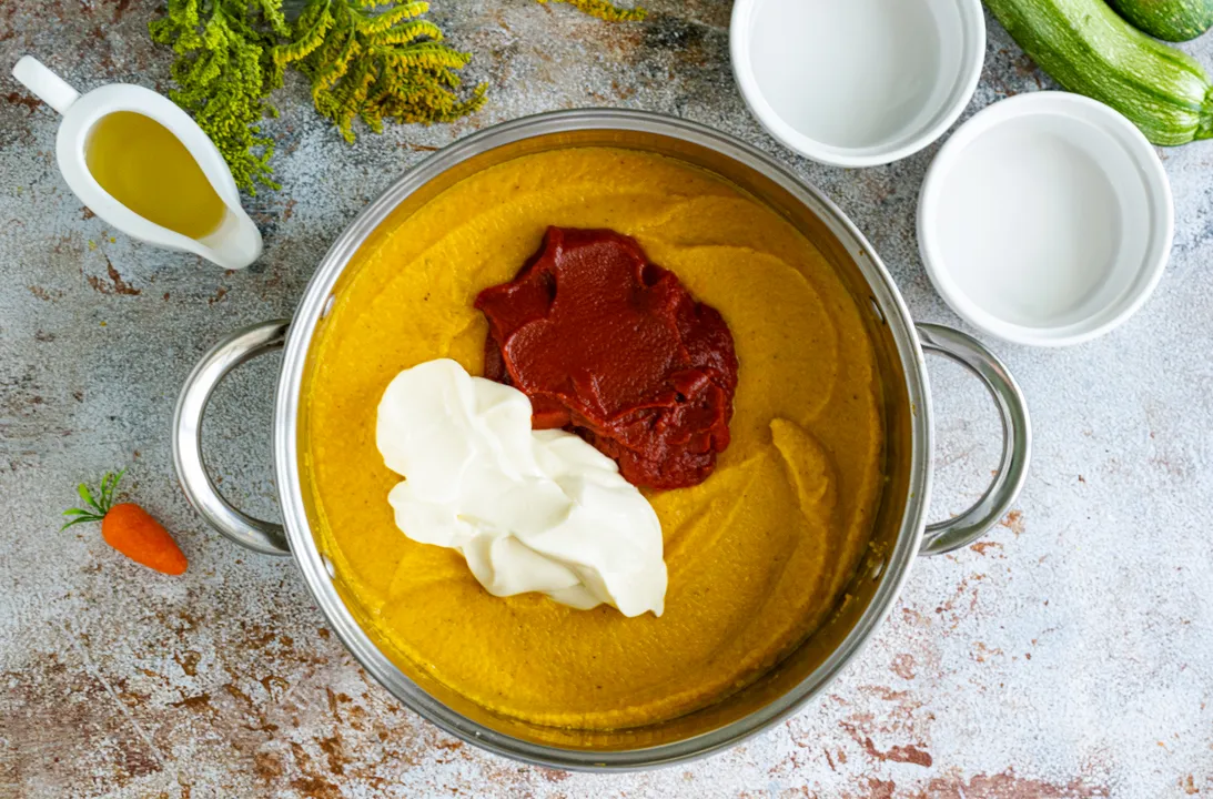 Додайте в кабачкову ікру якісний майонез та томатну пасту від перевіреного виробника. Ретельно перемішайте інгредієнти до однорідної консистенції.