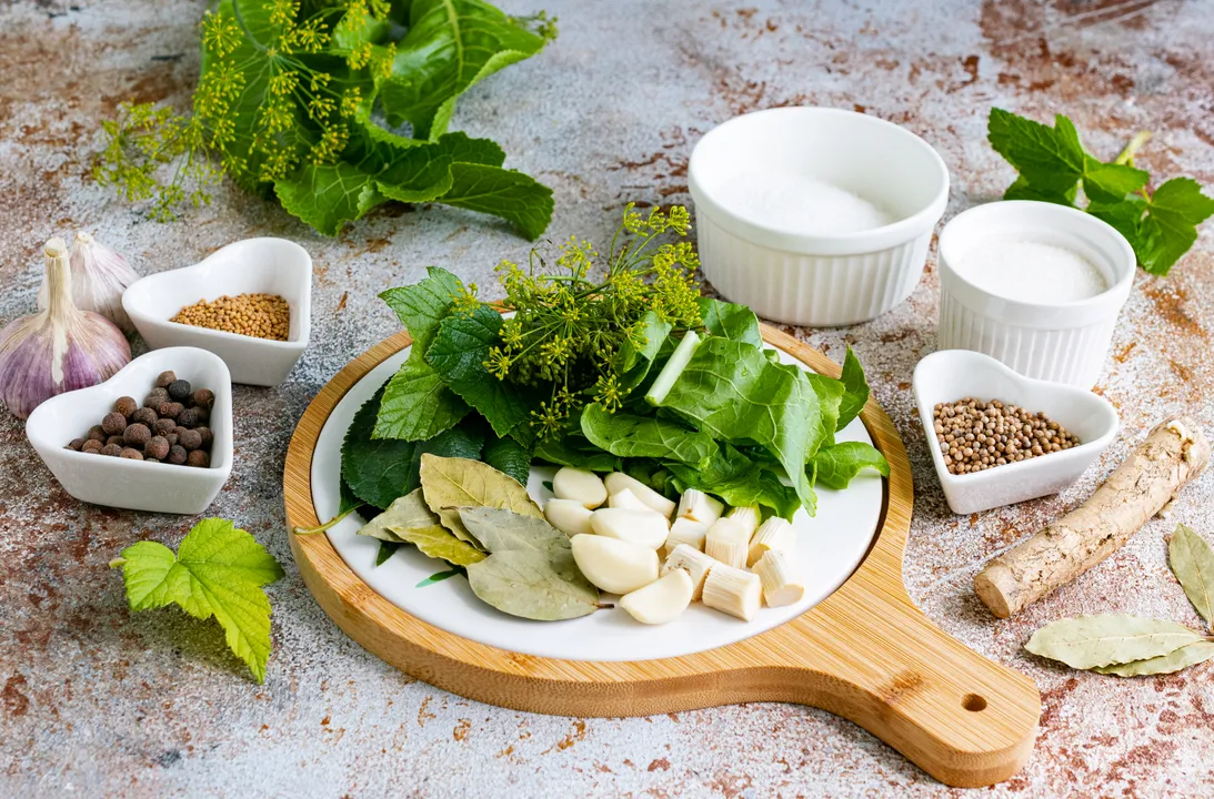 Peel the garlic cloves. Wash and peel the horseradish root, then cut it into 1 cm pieces. Wash the greens, and coarsely chop the horseradish leaves and dill sprigs.