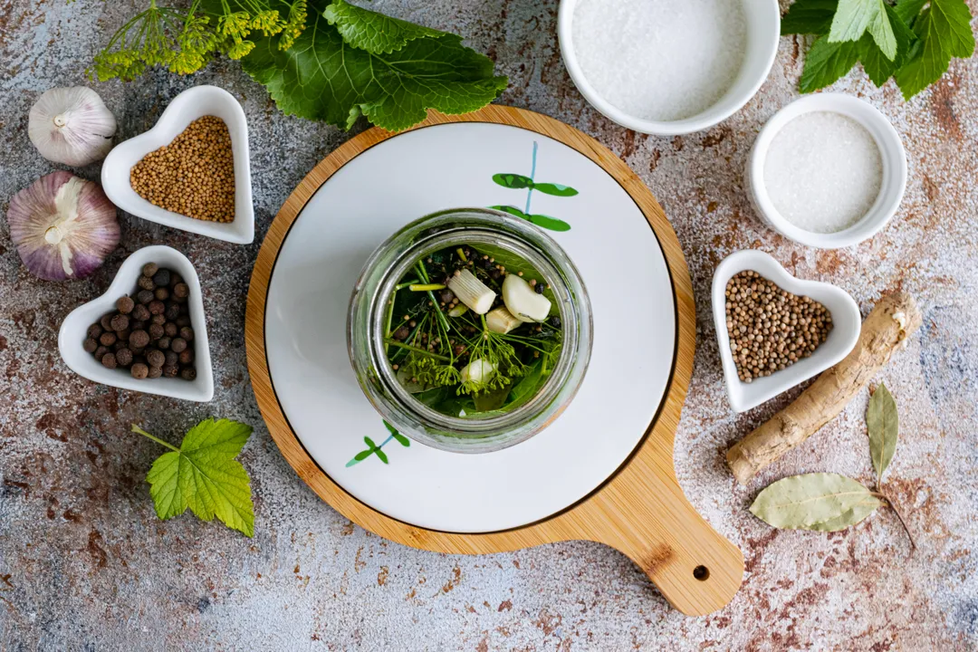 Thoroughly wash one-liter jars and sterilize them using any convenient method: steaming, in the oven, or in the microwave. At the bottom of each prepared jar, place 1 bay leaf, blackcurrant leaf, apple leaf, and cherry leaf. Add a clove of garlic, horseradish root, and leaves. For aroma, add cloves, allspice, coriander, and mustard seeds to each jar.