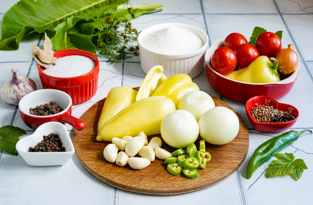 The marinade in this recipe is enough for 4 jars of 1.5 liters, 3 jars of 2 liters, or 2 jars of 3 liters. If you wish to preserve more, simply multiply the ingredients accordingly. Prepare the vegetables for canning. Sort through the tomatoes and wash them thoroughly. Peel the onions and garlic cloves. Wash the bell peppers, cut them in half, and remove the seed core. Wash the hot peppers and slice them into thin rings.