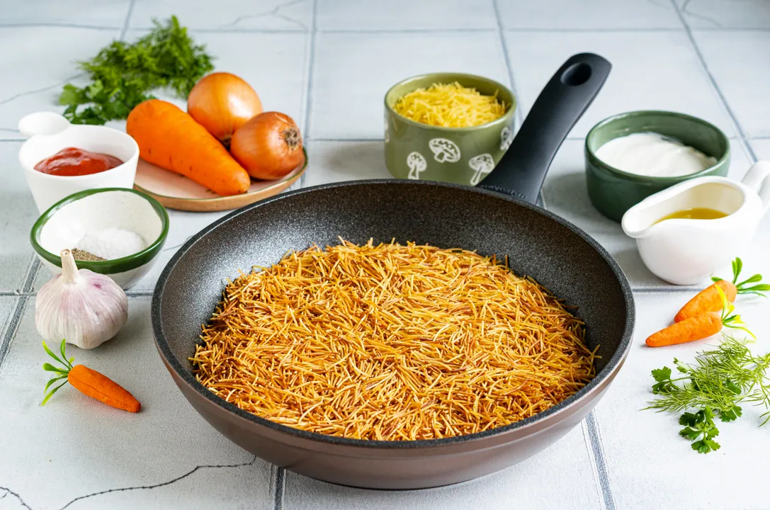 Тим часом обсмажте вермішель на сухій сковороді до золотистого відтінку. Не забувайте постійно помішувати вермішель, вона швидко змінює колір.