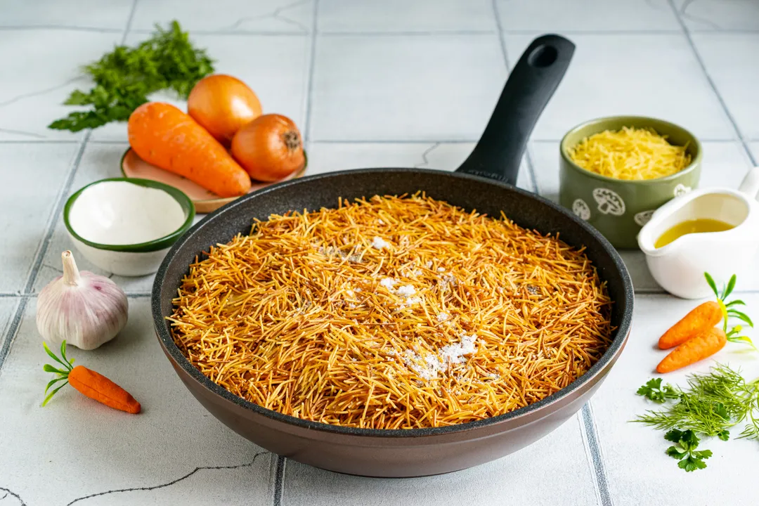 Зверху рівномірно розподіліть обсмажену вермішель. Посоліть за смаком, за бажанням приправте страву чорним меленим перцем.