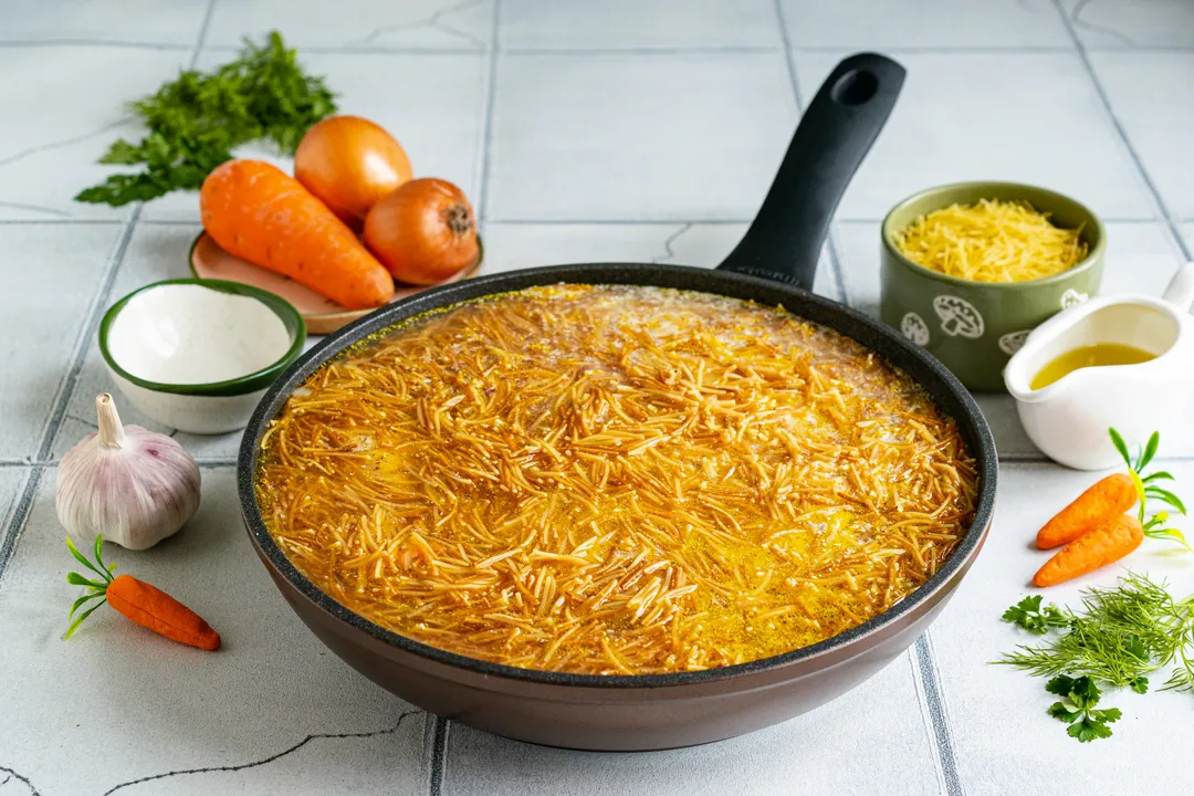 Влийте гарячу воду. Рідина має повністю покривати шматочки курки та вермішель.