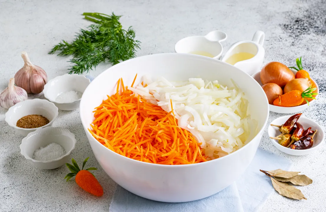 In a deep bowl, combine the chopped onion and grated carrots.
